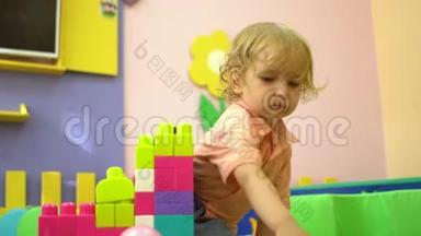 金发可爱的学龄前幼儿在<strong>幼儿园</strong>玩多种颜色的<strong>积木</strong>。 儿童发展